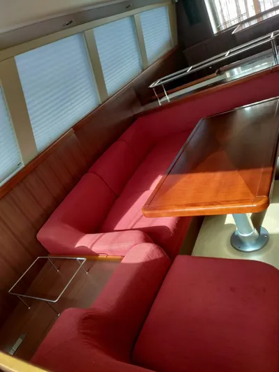 Felitsata II Yacht Photos Pics Luxurious interior of 2011 Hanse 62 DS yacht with red seating and wooden table.