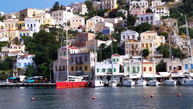 Felitsata II Yacht Photos Pics Colorful hillside houses and boats in a scenic harbor, featuring a 2011 Hanse 62 DS yacht.