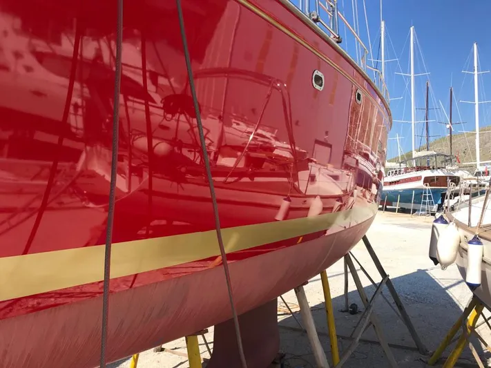 Felitsata II Yacht Photos Pics Red Hanse 62 DS yacht, 2011 model, docked with vibrant hull and gold stripe.