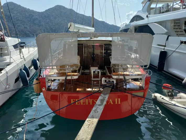 Felitsata II Yacht Photos Pics 2011 Hanse 62 DS yacht docked, red hull, scenic mountain backdrop.