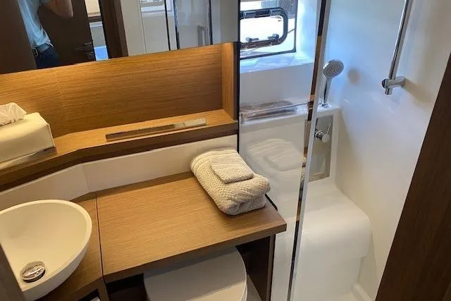  Yacht Photos Pics Modern bathroom in 2022 Jeanneau Leader 46 yacht with wooden accents and shower.