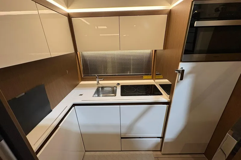  Yacht Photos Pics Modern kitchen in 2022 Jeanneau Leader 46 yacht with sleek cabinetry and appliances.