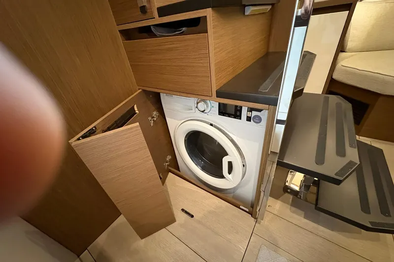  Yacht Photos Pics Laundry area inside 2022 Jeanneau Leader 46 yacht, featuring a built-in washing machine.