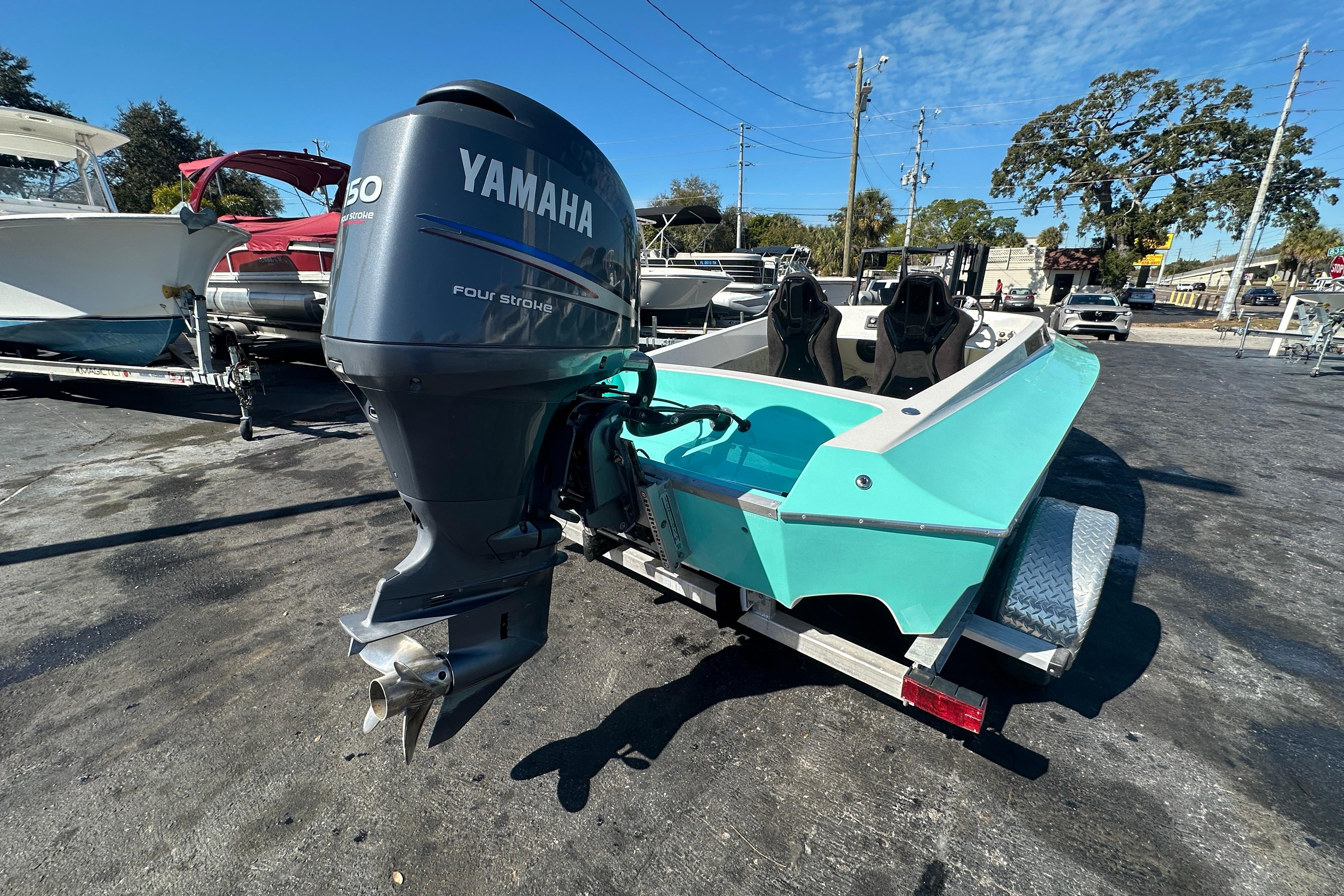Turquoise Lightning 18 boat with Yamaha outboard motor on a trailer, 2022 model.