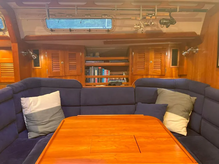 Harmony Yacht Photos Pics Luxurious 2005 Tillotson-Pearson J-160 yacht interior with cozy seating and wooden table.