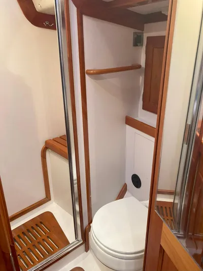 Harmony Yacht Photos Pics 2005 Tillotson-Pearson J-160 yacht bathroom with wooden accents and compact design.