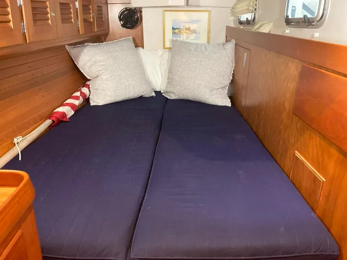 Harmony Yacht Photos Pics Cozy cabin interior of 2005 Tillotson-Pearson J-160 sailboat with blue bedding and pillows.