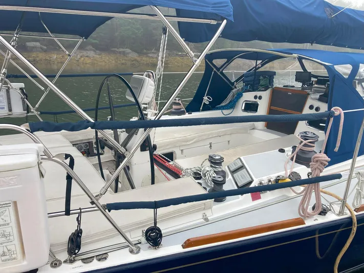 Harmony Yacht Photos Pics 2005 Tillotson-Pearson J-160 sailboat cockpit with blue canopy and steering wheel.