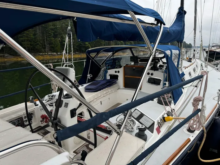 Harmony Yacht Photos Pics 2005 Tillotson-Pearson J-160 sailboat cockpit with blue canopy and steering wheel.