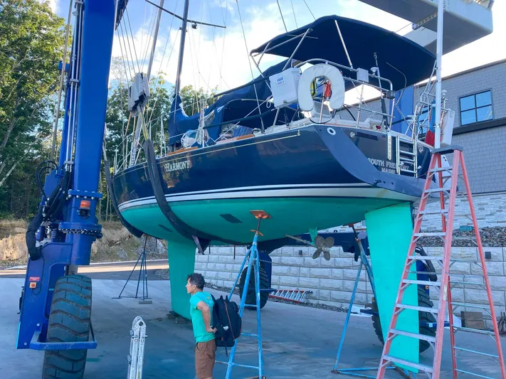 Harmony Yacht Photos Pics Sailboat Tillotson-Pearson J-160, 2005 model, on a lift for maintenance at a marina.