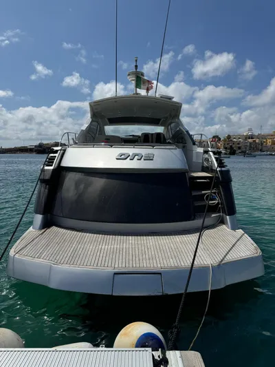  Yacht Photos Pics 2006 Pershing 56 yacht docked in clear blue water under a partly cloudy sky.