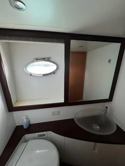 Yacht Photos Pics Bathroom interior of 2006 Pershing 56 yacht with sink, mirror, and porthole window.