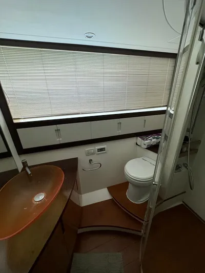  Yacht Photos Pics Luxurious bathroom in a 2006 Pershing 56 yacht with modern fixtures and wooden accents.