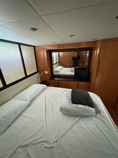  Yacht Photos Pics Luxurious bedroom interior of 2006 Pershing 56 yacht with wood paneling and cozy bedding.