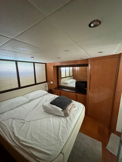  Yacht Photos Pics Luxurious bedroom interior of 2006 Pershing 56 yacht with cozy bed and wooden accents.