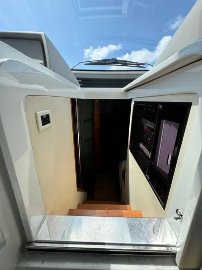  Yacht Photos Pics Interior view of 2006 Pershing 56 yacht, showing stairs leading below deck under a sunny sky.