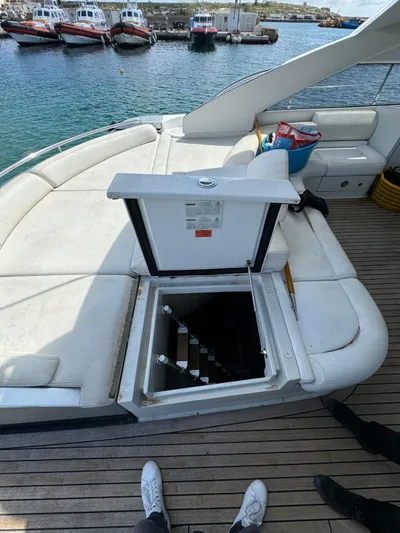  Yacht Photos Pics 2006 Pershing 56 yacht with open hatch and stairs, docked near other boats.