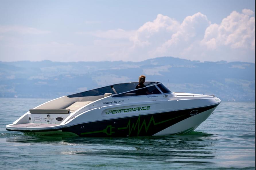 2023 Performance e801 electric boat cruising on a serene lake with mountains in the background.