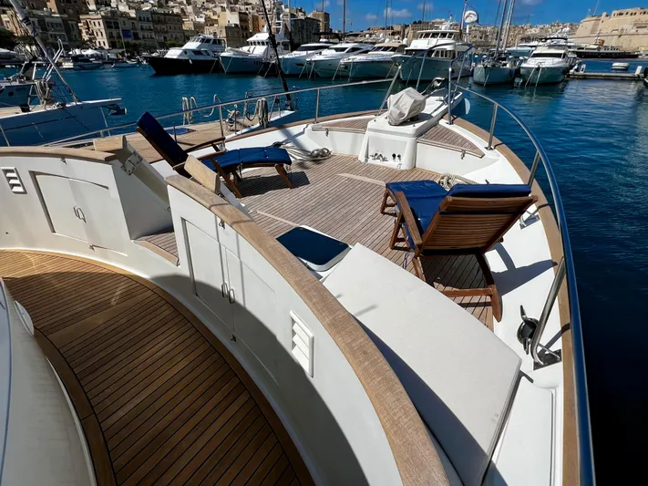  Yacht Photos Pics Luxurious 1996 Fleming 55 yacht with sun loungers, docked in a scenic marina.