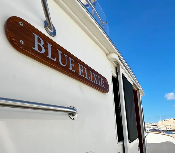  Yacht Photos Pics Fleming 55 yacht "Blue Elixir" nameplate against a clear blue sky, 1996 model.