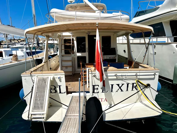  Yacht Photos Pics 1996 Fleming 55 yacht docked, featuring spacious deck and flag, in a sunny marina.