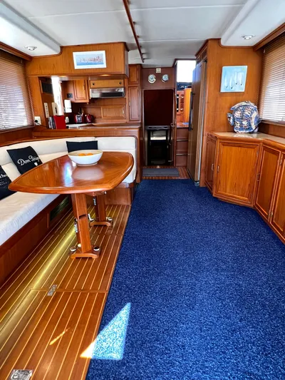  Yacht Photos Pics Interior of a 1996 Fleming 55 yacht with wooden furnishings and blue carpet.