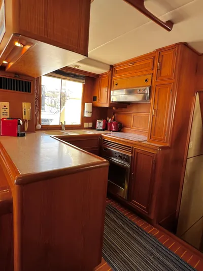  Yacht Photos Pics 1996 Fleming 55 yacht kitchen with wooden cabinetry and modern appliances.