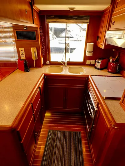  Yacht Photos Pics 1996 Fleming 55 yacht kitchen with wood cabinetry, dual sinks, and modern appliances.