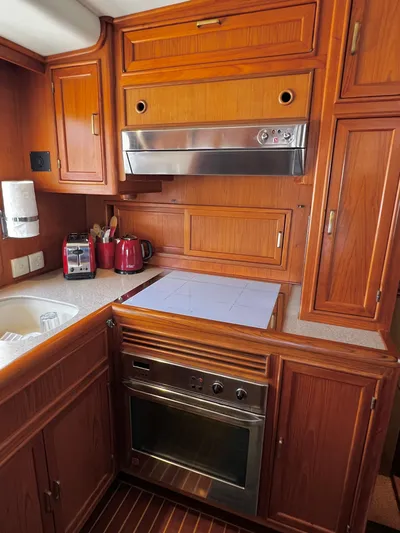  Yacht Photos Pics 1996 Fleming 55 yacht kitchen with wooden cabinetry and modern appliances.