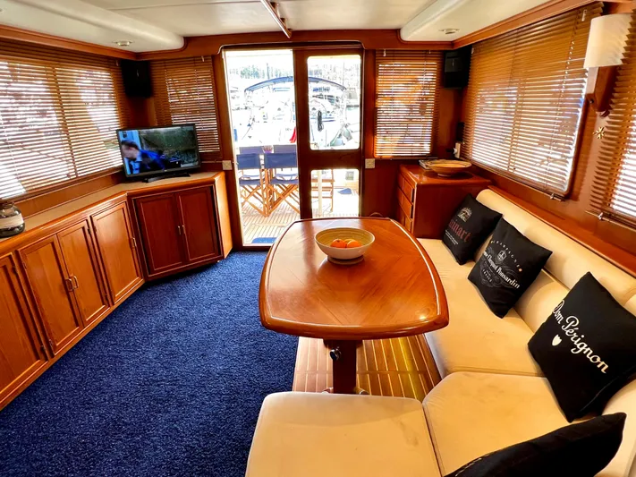  Yacht Photos Pics Luxurious 1996 Fleming 55 yacht interior with cozy seating, wooden table, and TV.