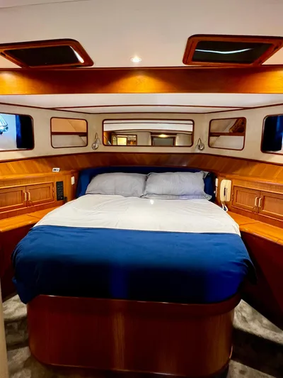  Yacht Photos Pics Luxurious cabin interior of a 1996 Fleming 55 yacht with a cozy bed and wooden accents.