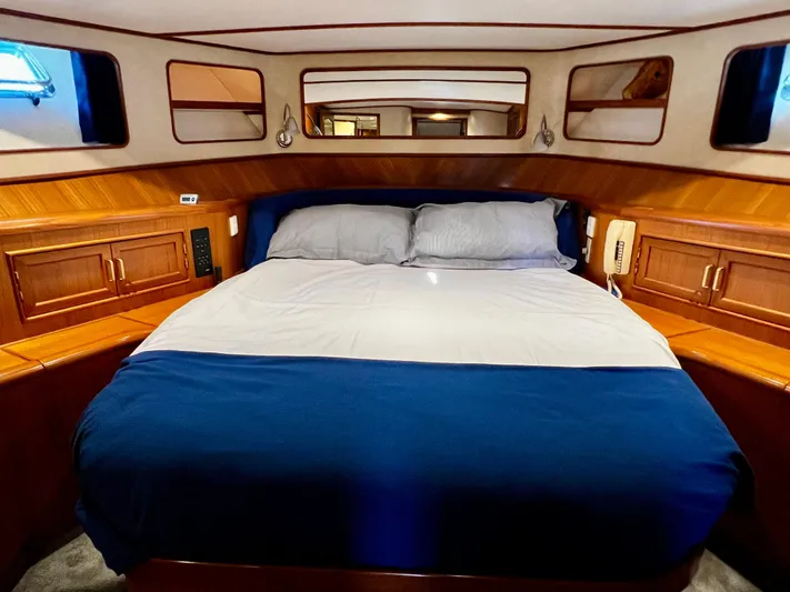  Yacht Photos Pics Luxurious bedroom in a 1996 Fleming 55 yacht with wood accents and cozy bedding.