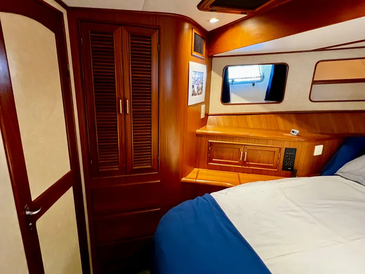  Yacht Photos Pics Cozy cabin interior of a 1996 Fleming 55 yacht with wooden furnishings and a porthole window.