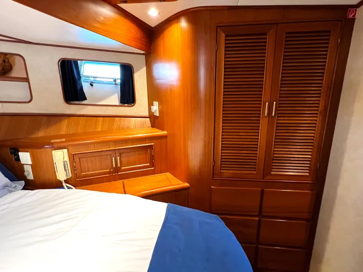  Yacht Photos Pics Cozy cabin interior of 1996 Fleming 55 yacht with wooden cabinetry and bed.