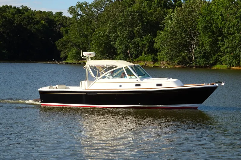 Narwhal Yacht Photos Pics 2007 Hunt Yachts Surfhunter 29 cruising on a serene lake with lush green trees.