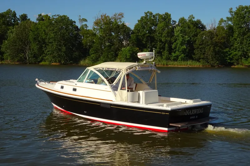 Narwhal Yacht Photos Pics 2007 Hunt Yachts Surfhunter 29 cruising on a serene lake with lush green trees.