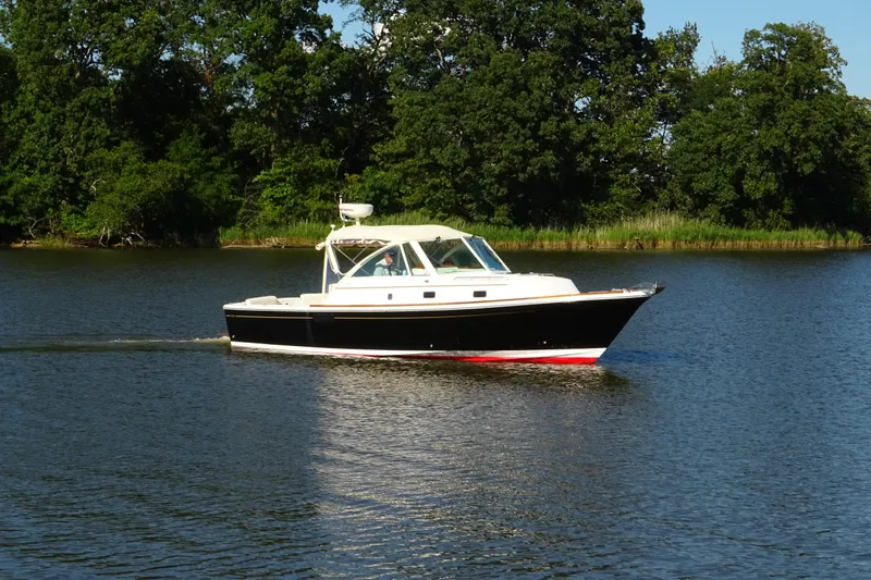 Narwhal Yacht Photos Pics 2007 Hunt Yachts Surfhunter 29 cruising on a serene lake with lush green trees.