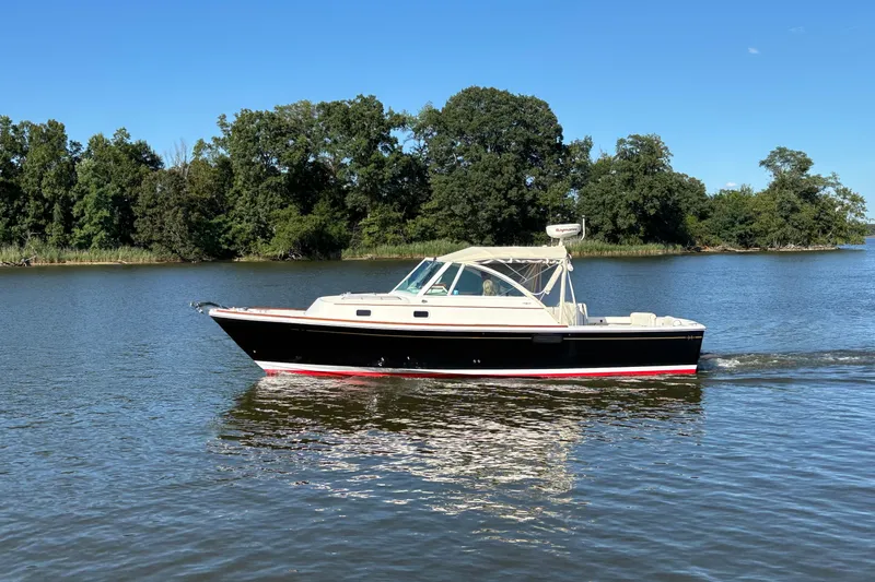 Narwhal Yacht Photos Pics 2007 Hunt Yachts Surfhunter 29 cruising on a serene lake with lush green trees.
