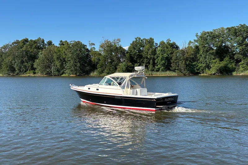 Narwhal Yacht Photos Pics 2007 Hunt Yachts Surfhunter 29 cruising on a serene lake with lush green trees.