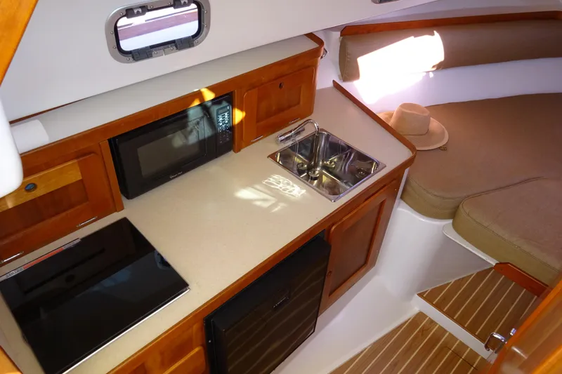 Narwhal Yacht Photos Pics 2007 Hunt Yachts Surfhunter 29 interior with kitchenette, sink, microwave, and cozy seating area.