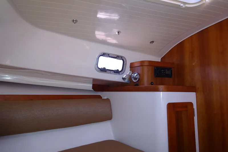 Narwhal Yacht Photos Pics Interior of 2007 Hunt Yachts Surfhunter 29 with wood paneling and porthole window.