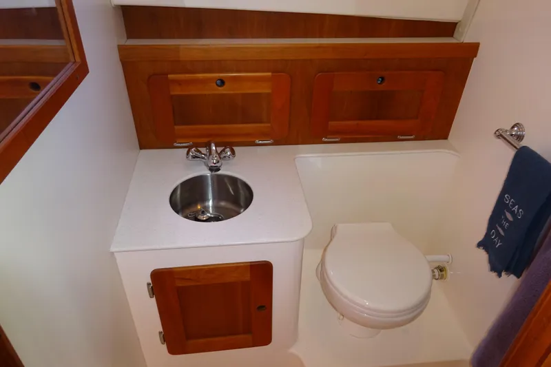 Narwhal Yacht Photos Pics 2007 Hunt Yachts Surfhunter 29 bathroom with sink, toilet, and wooden cabinetry.
