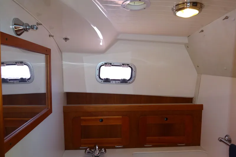 Narwhal Yacht Photos Pics 2007 Hunt Yachts Surfhunter 29 interior with wooden cabinetry and porthole window.