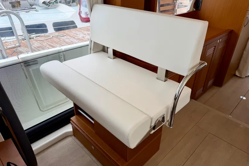  Yacht Photos Pics 2026 Beneteau Swift Trawler 41 Fly interior with white cushioned seating and wooden accents.