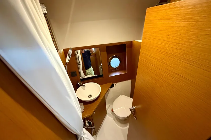  Yacht Photos Pics 2026 Beneteau Swift Trawler 41 Fly bathroom with modern fixtures and wooden accents.
