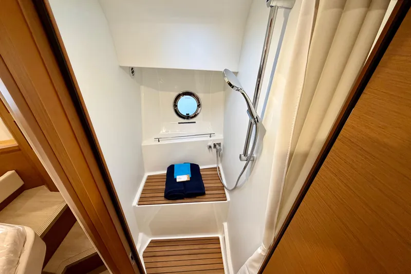 Yacht Photos Pics Shower area in 2026 Beneteau Swift Trawler 41 Fly with wooden flooring and porthole.