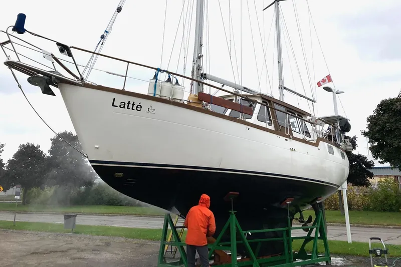 Latte Yacht Photos Pics 1987 Nauticat 38 sailboat "Latt&eacute;" on dry dock, Canadian flag, person in orange jacket.