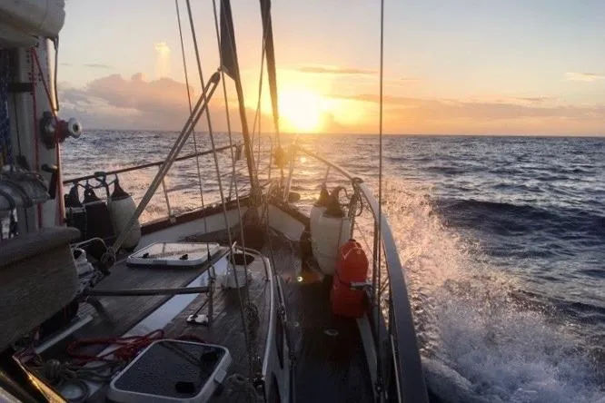 Latte Yacht Photos Pics Sailing Nauticat 38 yacht at sunset, 1987 model, ocean waves splashing.