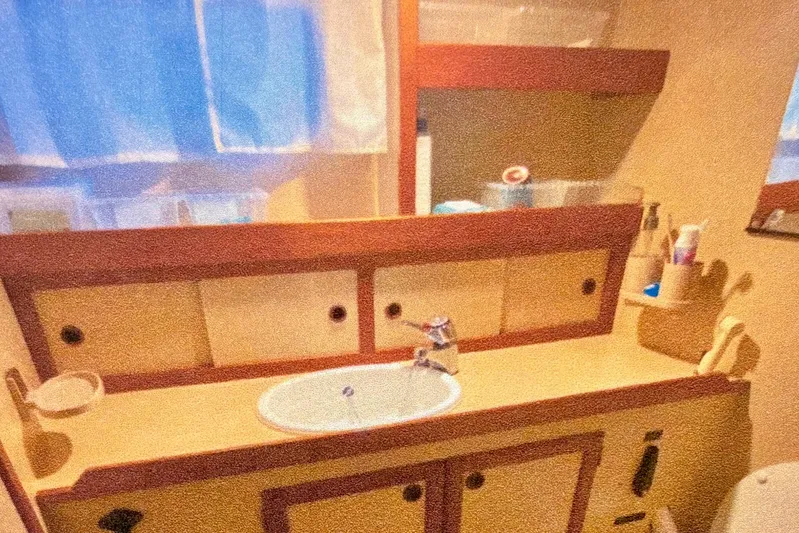Latte Yacht Photos Pics 1987 Nauticat 38 yacht bathroom with sink, mirror, and storage cabinets.