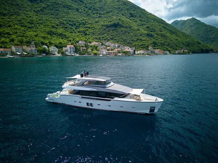  Yacht Photos Pics Luxurious 2020 Sanlorenzo SX88 yacht cruising near a scenic coastal village.